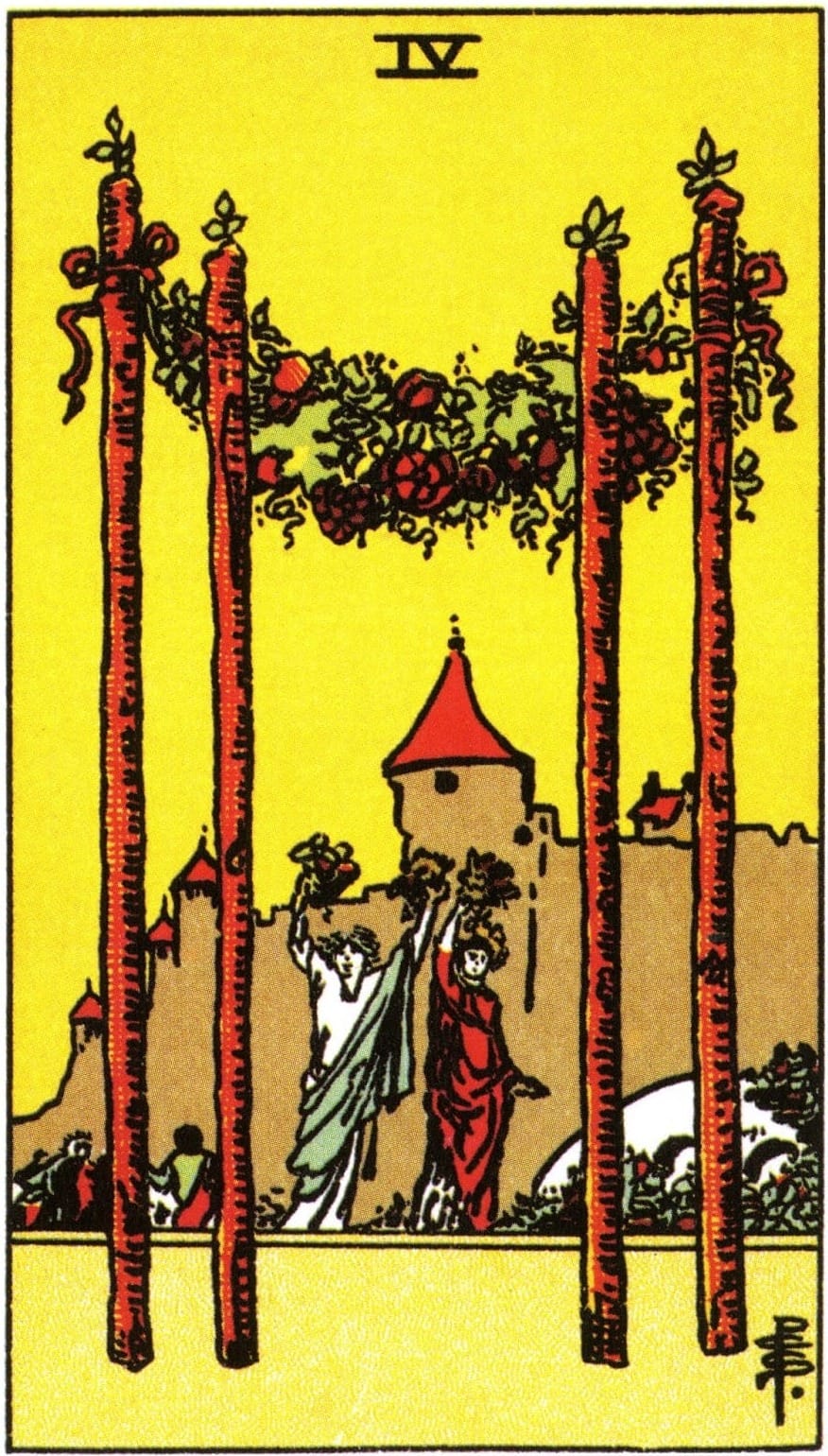 Two people hold garlands overhead between 4 upright wands with more garlands on them. A crowd and castle are in the background.