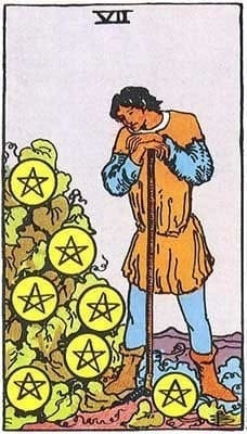 A figure hunches over a harvest tool and a shrub with 7 pentacles.